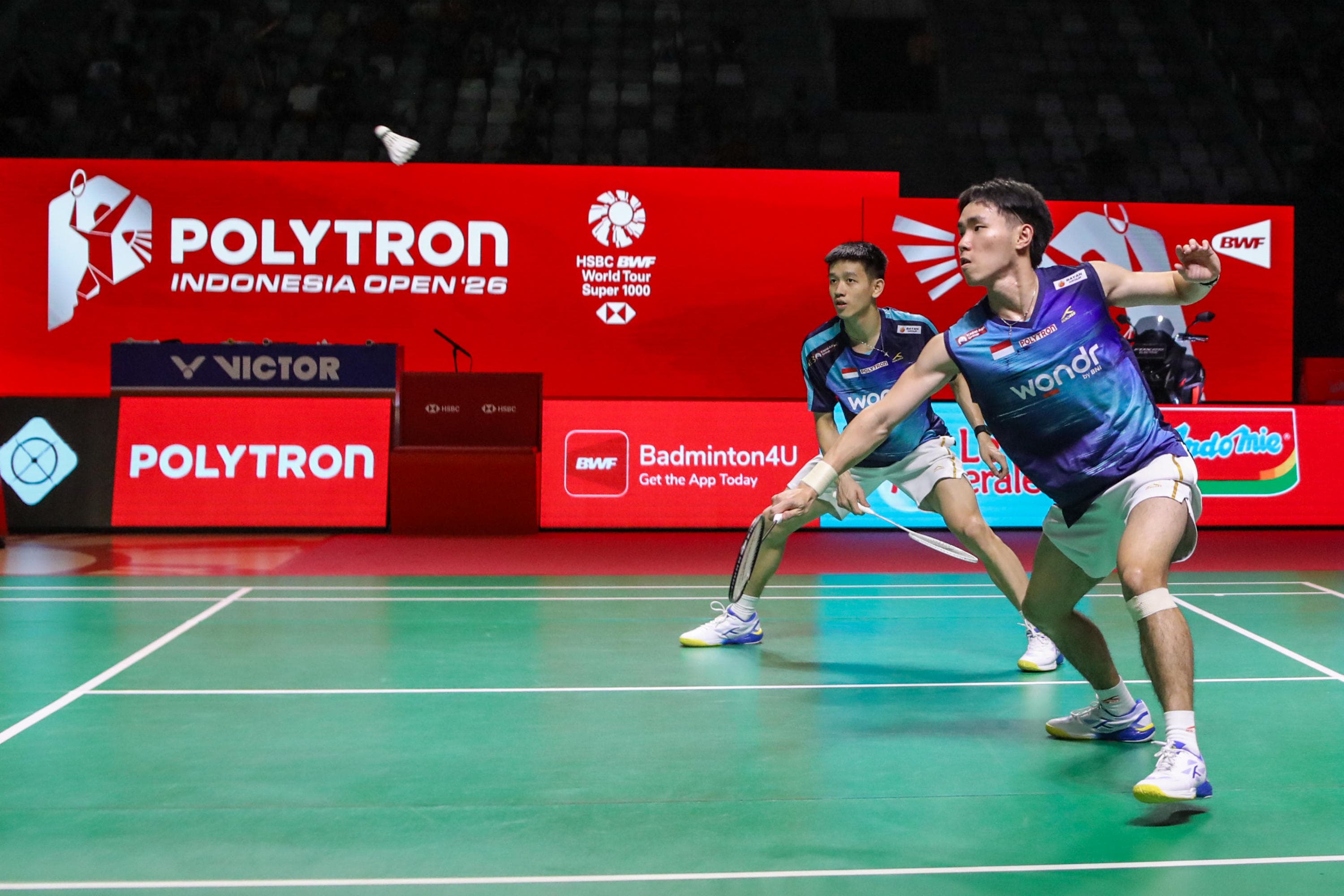 Pebulu tangkis ganda putra Indonesia Raymond Indra/Nikolaus Joaquin mengembalikan kok ke arah pebulu tangkis ganda putra Jepang Takuro Hoki/Yugo Kobayashi dalam perempat final Polytron Indonesia Open di Istora Senayan, Jakarta, Jumat (5/6/2026). AKURAT.CO/Endra Prakoso 