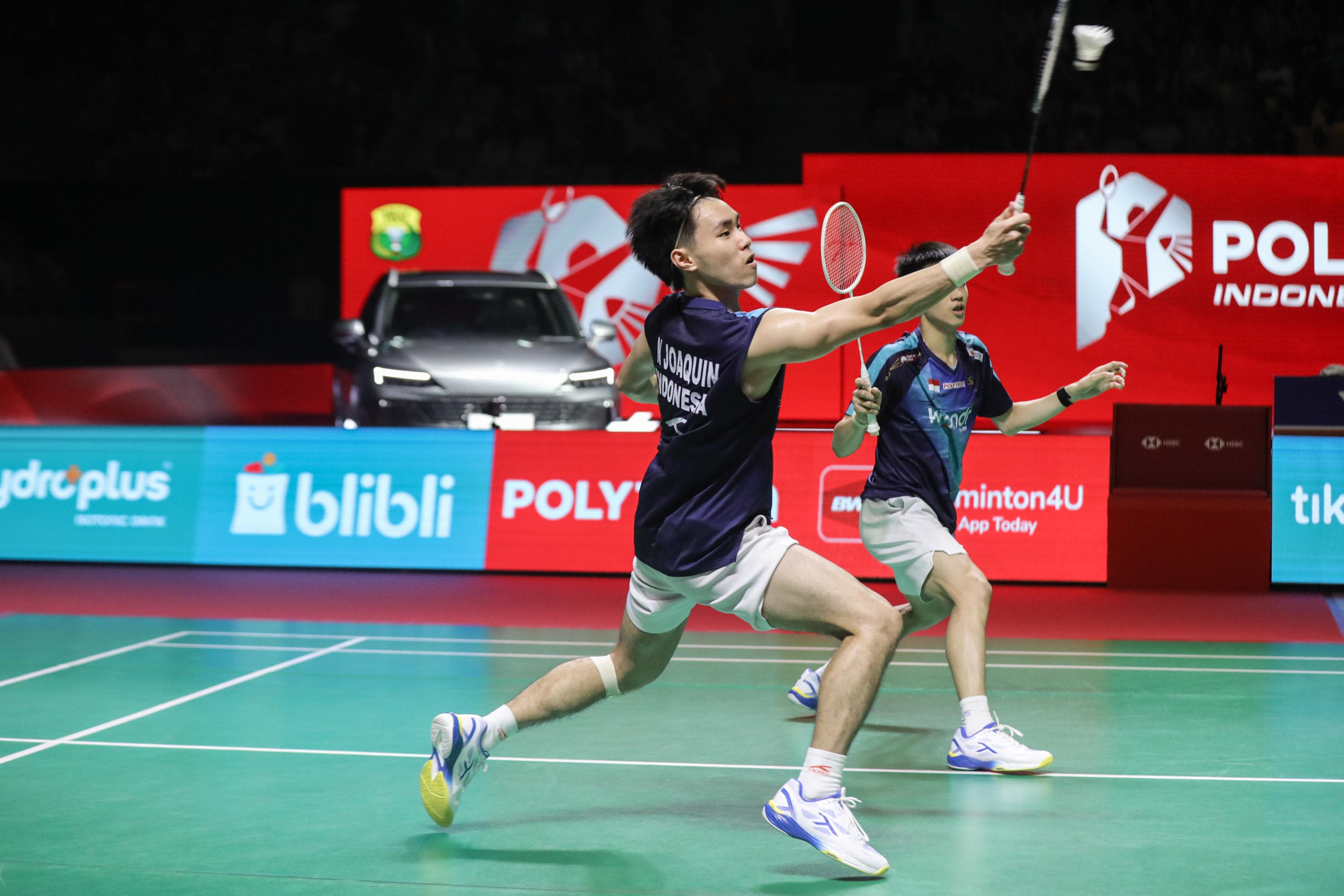 Pebulu tangkis ganda putra Indonesia Raymond Indra/Nikolaus Joaquin mengembalikan kok ke arah pebulu tangkis ganda putra Jepang Takuro Hoki/Yugo Kobayashi dalam perempat final Polytron Indonesia Open di Istora Senayan, Jakarta, Jumat (5/6/2026). AKURAT.CO/Endra Prakoso 