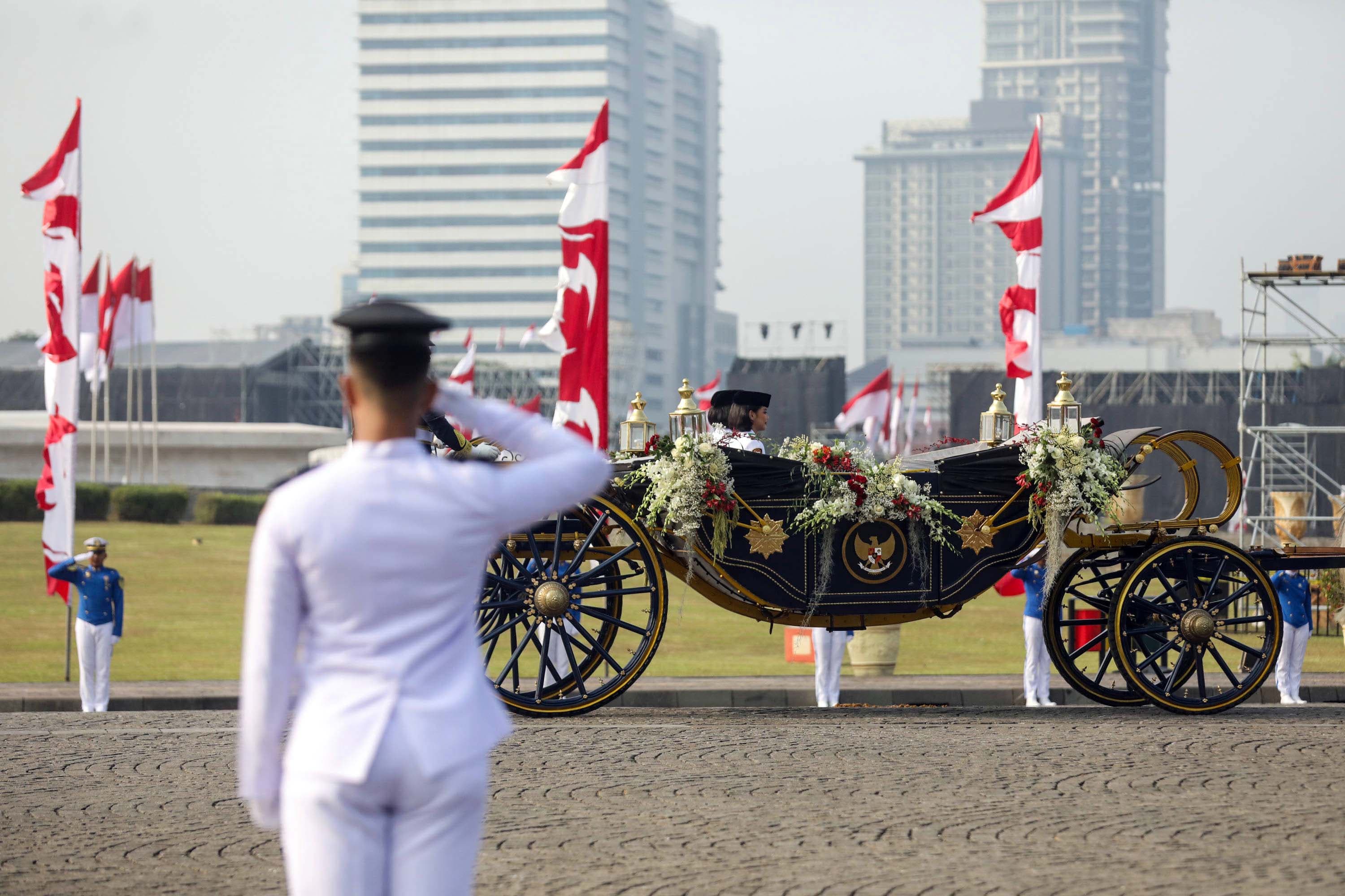 urna Paskibraka Duta Pancasila 2025 Bianca Sultana Najwa (kanan) dan Aliah Sakira (kedua kanan) membawa bendera pusaka dan naskah Proklamasi di atas kereta kencana Garuda Prabayaksa dari Monumen Nasional menuju Istana Merdeka dalam kirab Merah Putih di Jakarta, Senin (17/8/2026). AKURAT.CO/Endra Prakoso