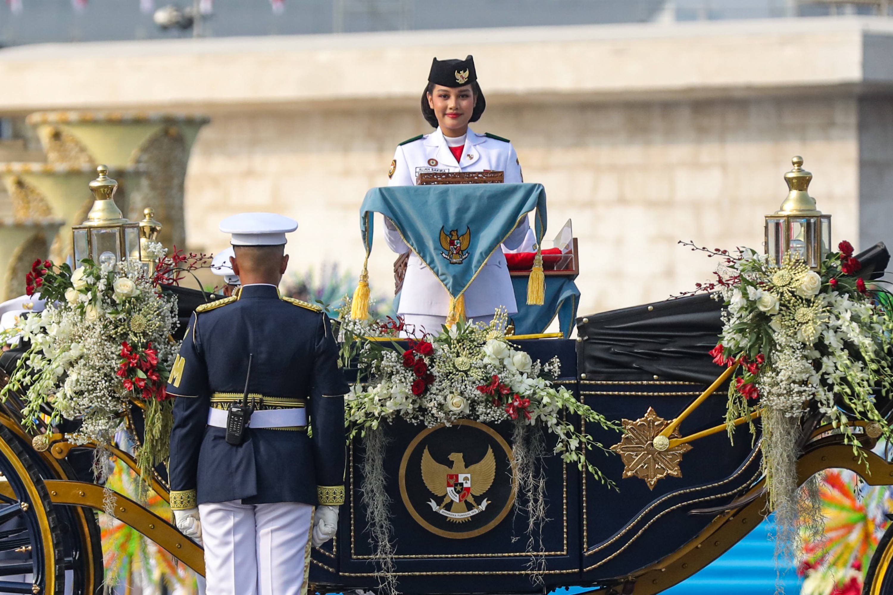 Purna Paskibraka Duta Pancasila 2025 Bianca Sultana Najwa membawa bendera pusaka di atas kereta kencana Garuda Prabayaksa dari Monumen Nasional menuju Istana Merdeka dalam kirab Merah Putih di Jakarta, Senin (17/8/2026). AKURAT.CO/Endra Prakoso