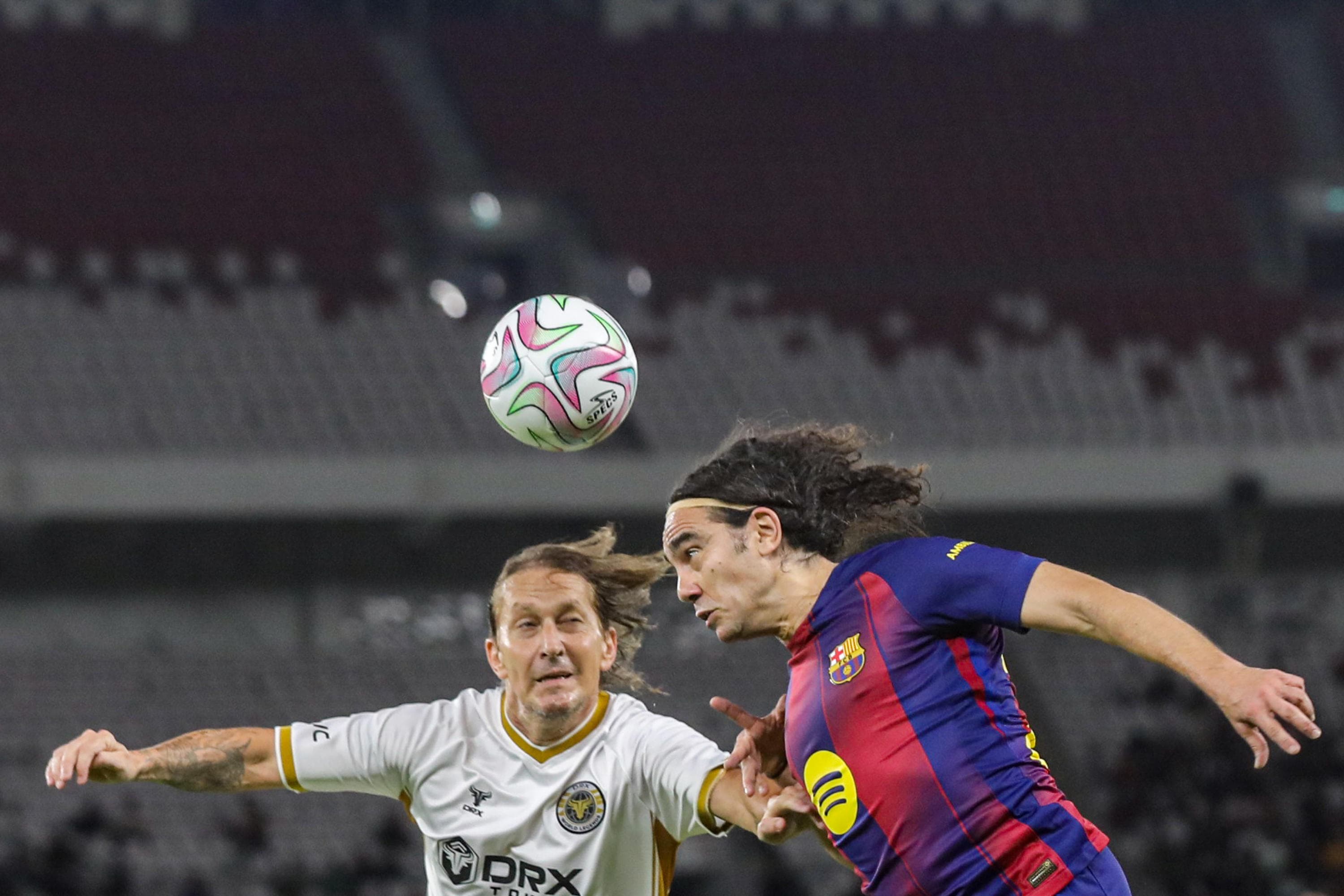 Legenda sepak bola dunia, Michel Salgado (kiri) berebut bola dengan legenda sepak bola Barcelona Juan Pablo Sorin (kanan) dalam laga Clash of Legends di Stadion Utama Gelora Bung Karno (SUGBK), Senayan, Jakarta, Sabtu (18/4/2026). AKURAT.CO/Endra Prakoso